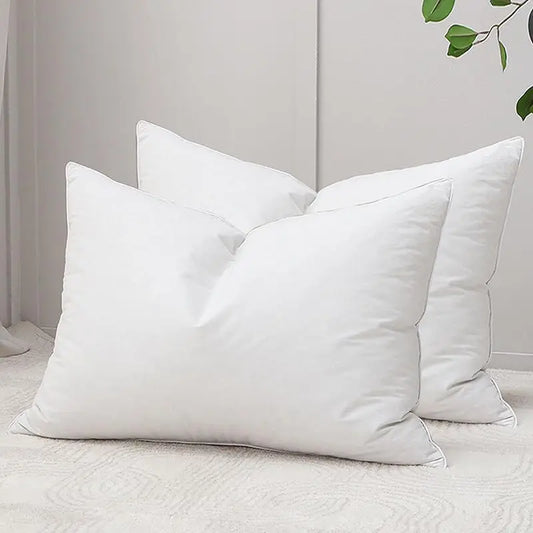 Three white pillows on a bed with a neutral background